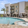 resort style pool with seating with a building behind it