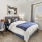 a bedroom with a bed and a chair and window