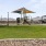 a large green field with a gazebo and a playground