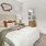 a bedroom with a bed and a fan and side table
