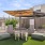 a patio with a fence and a bench and a table with a umbrella