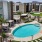 a pool in a courtyard with lounge chairs and cabanas